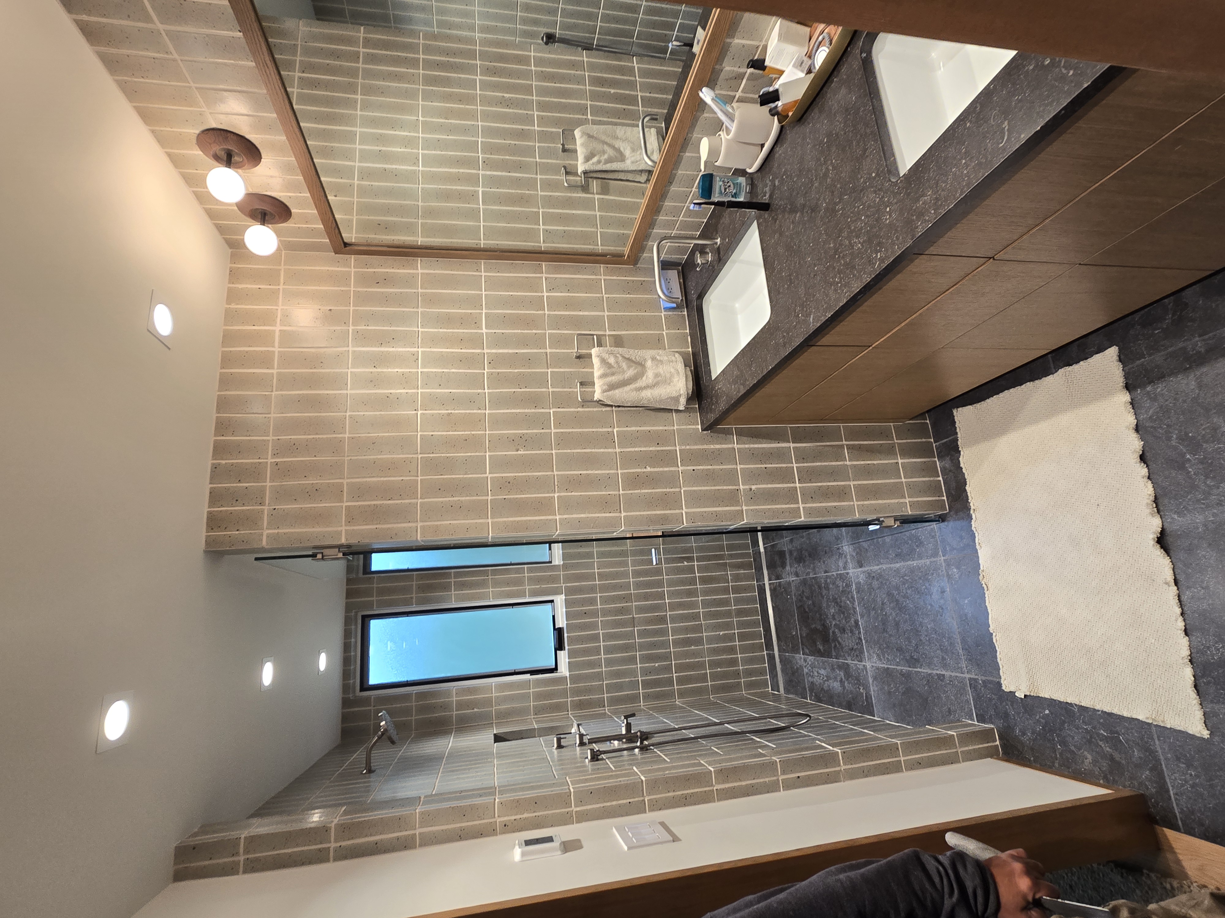 Full master bathroom with deck mount tub, artisan wall tile and dark floor tile