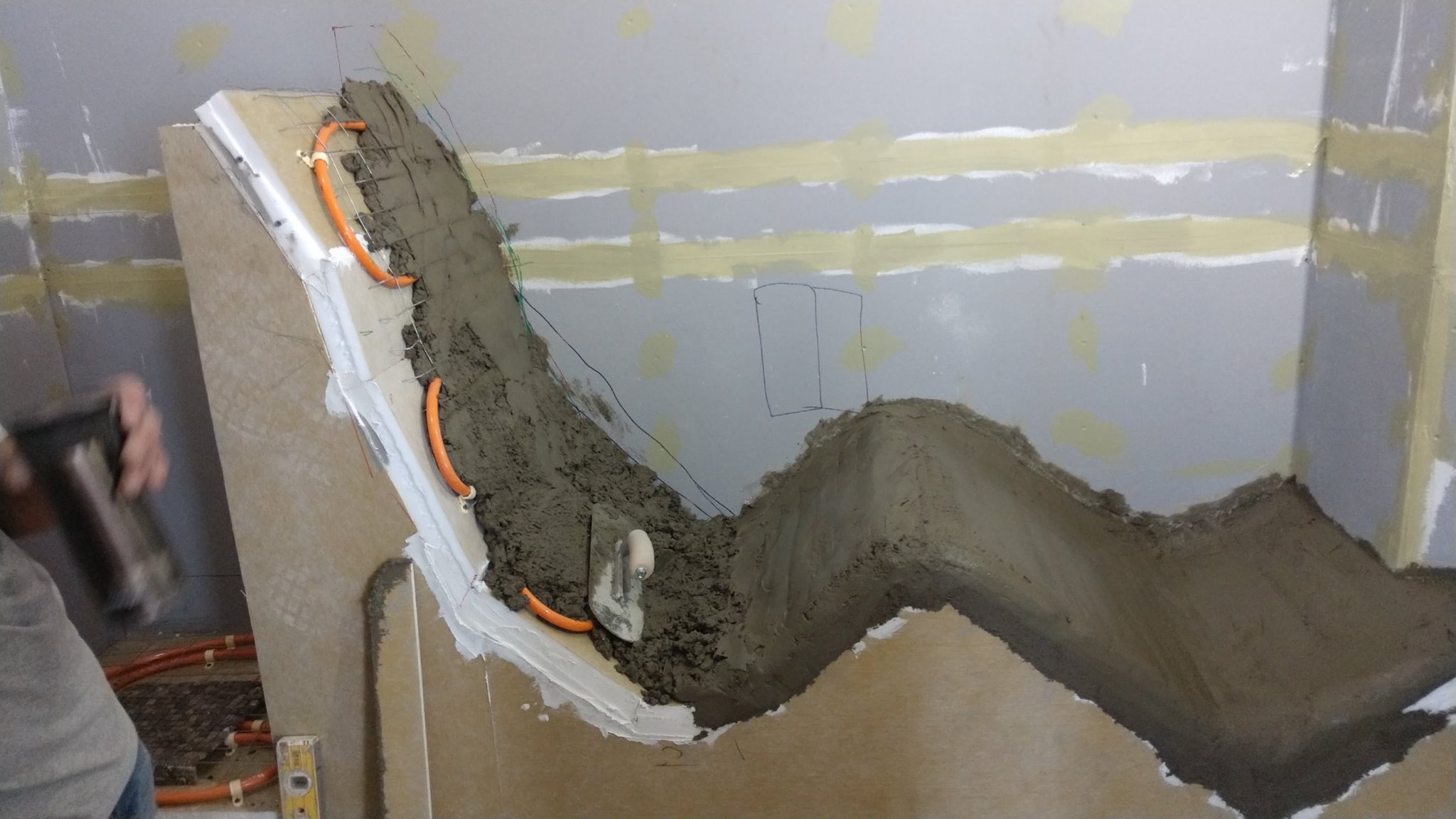 Mortar bed and radiant heat tubing during shower recliner construction